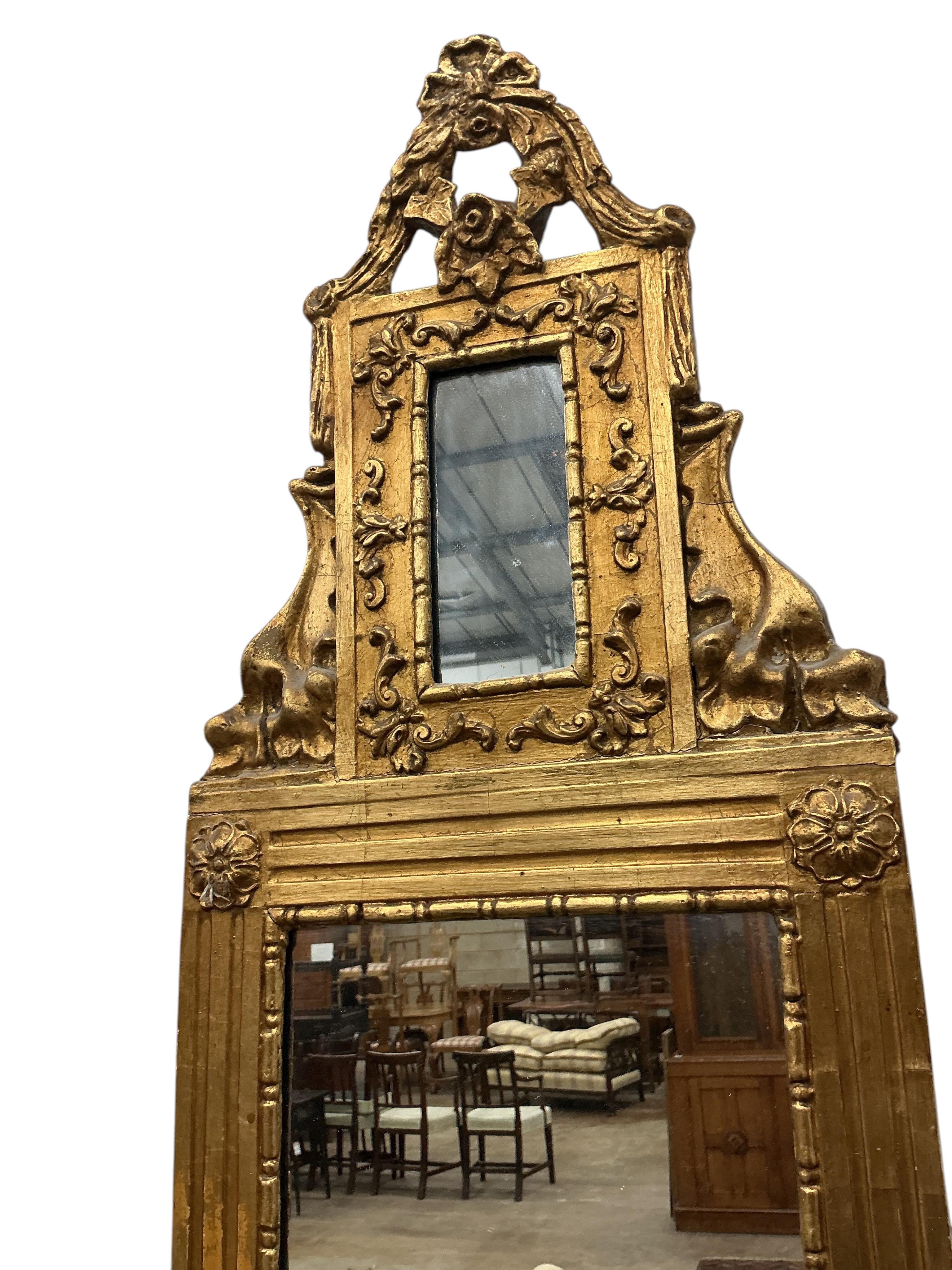 A small carved giltwood and composition wall mirror, width 33cm, height 110cm